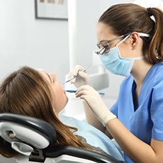dentist treating a patient for a dental cleaning in Hurst, TX.