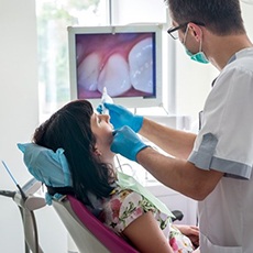 dentist with a patient during her dental exam in Hurst, TX.