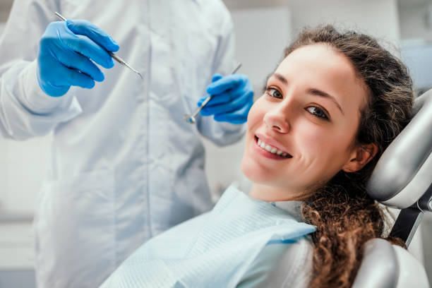 a woman smiling while lying on the dental chair