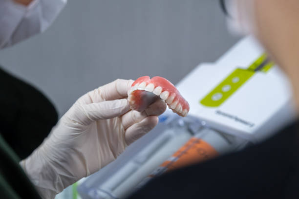 a dentist holding a dental prosthesis